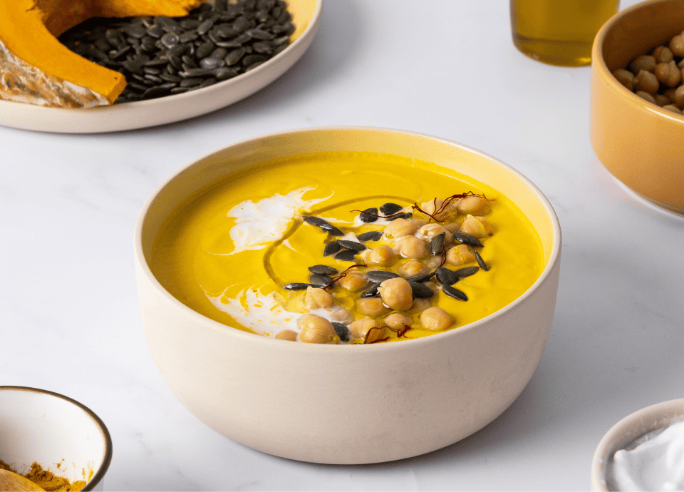 Soupe courge jaune mixée au blender avec graines pois chiches et crème fraîche
