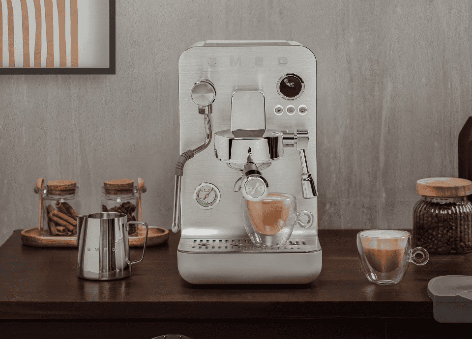 Machine à café manuelle semi-professionnelle EMC02WHMEU blanche Smeg sur un plan de travail