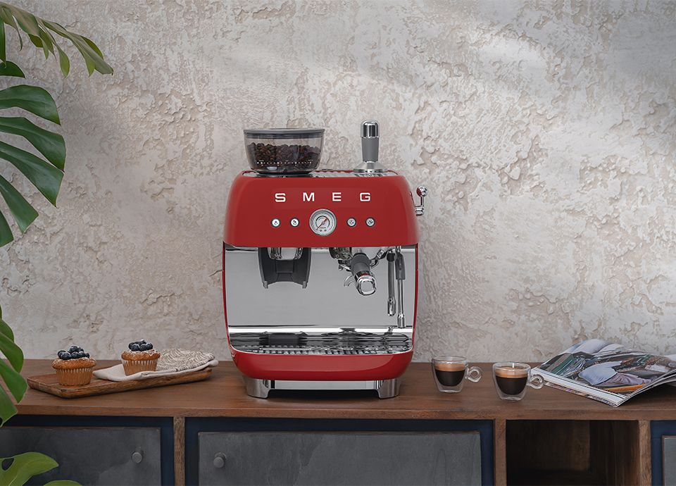 Machine à café avec broyeur intégré EGF03RDEU rouge Smeg sur un plan de travail