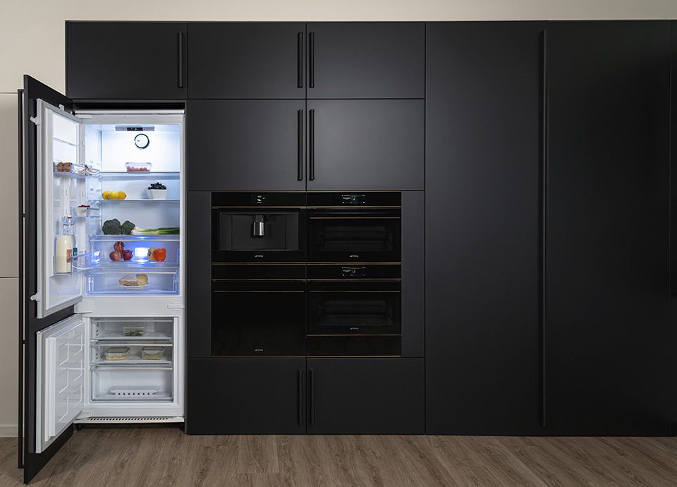Frigorifero da incasso Smeg con congelatore nella parte inferiore, porte aperte per mostrare larghezza da 75 cm e capienza maggiore dei modelli standard