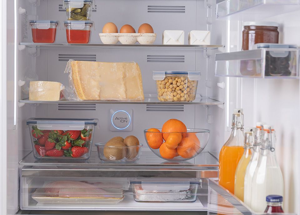 Interno del frigorifero con alimenti riposti sui 3 ripiani e vani della controporta