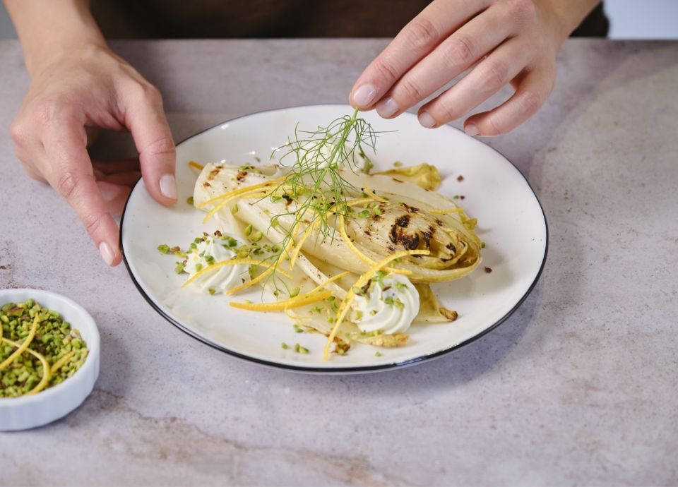 Endive with orange sauce, robiola and pistachios