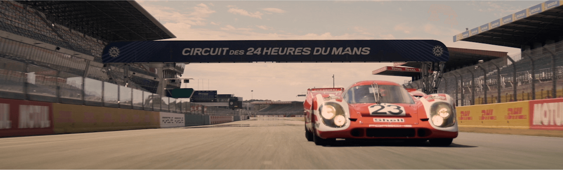 The Porsche 917 KH, featuring its classic red and white Salzburg livery, is seen racing on the Le Mans track during its historic 1970 victory.