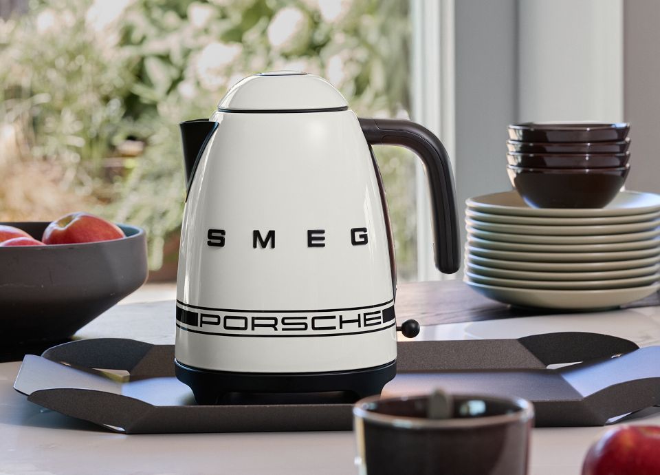 Carrara White Porsche x SMEG kettle in a kitchen surrounded by kitchen utensils