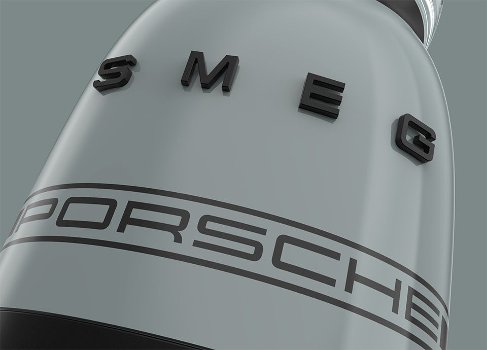 Detail of the blender in colour shade green. The base features the brand name "SMEG" in large uppercase letters, and below it, the word "PORSCHE" in smaller uppercase letters.