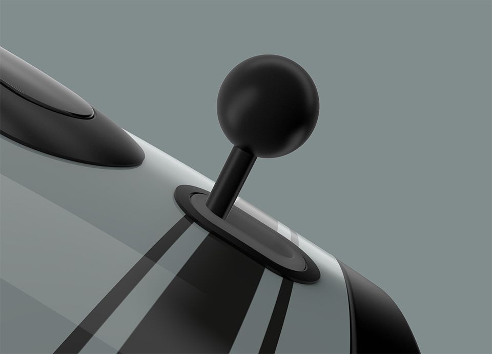 Detail of the control lever of the kettle in colour shade green. The black rounded control lever is positioned on the right side of the base of the kettle.