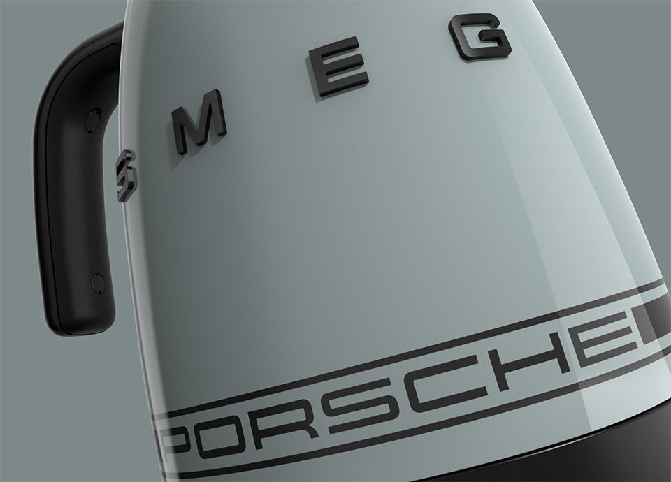 Detail of the kettle in colour shade green. The handle of the kettle is black and the central body displays the brand name "SMEG" in bold black uppercase letters. Near the bottom, a horizontal black band features the word "PORSCHE" in black uppercase letters.