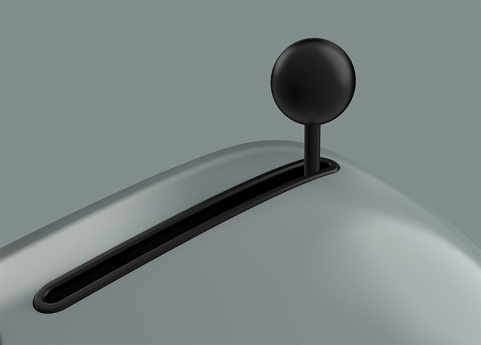 Detail of the control lever of the toaster in colour shade green. The black rounded control lever is positioned on the right side of the base of the toaster.