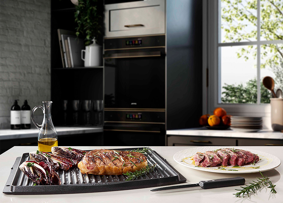 Una teglia da forno barbecue con pezzi di carne e verdure fresche in cottura.