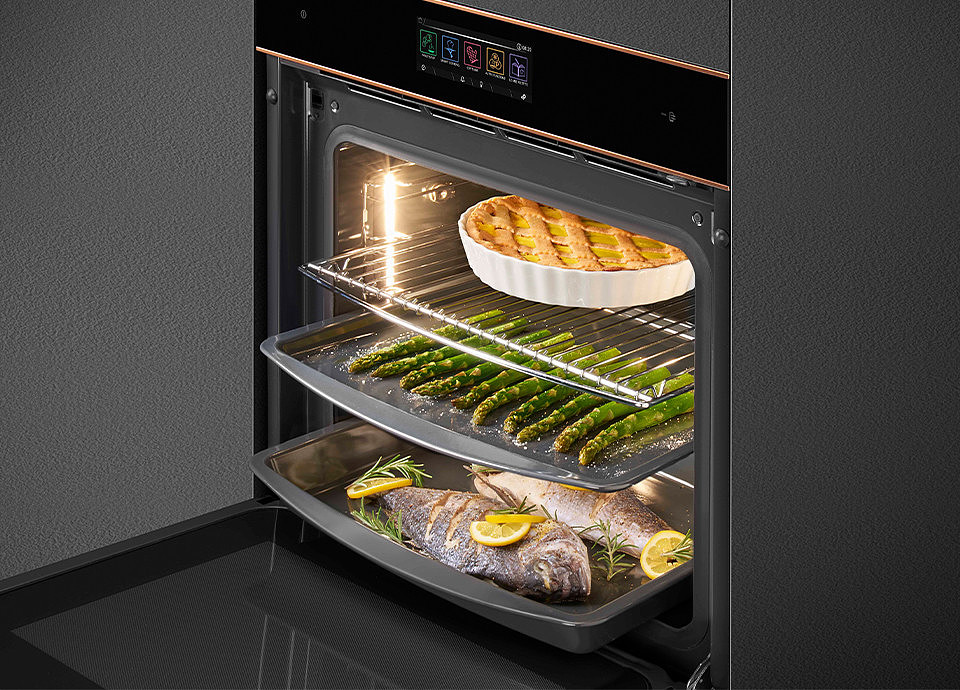 Un forno di colore nero che contiene del cibo in fase di cottura su vari livelli